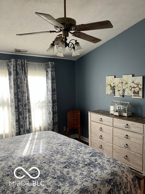 unfurnished bedroom featuring ceiling fan, a textured ceiling, and vaulted ceiling