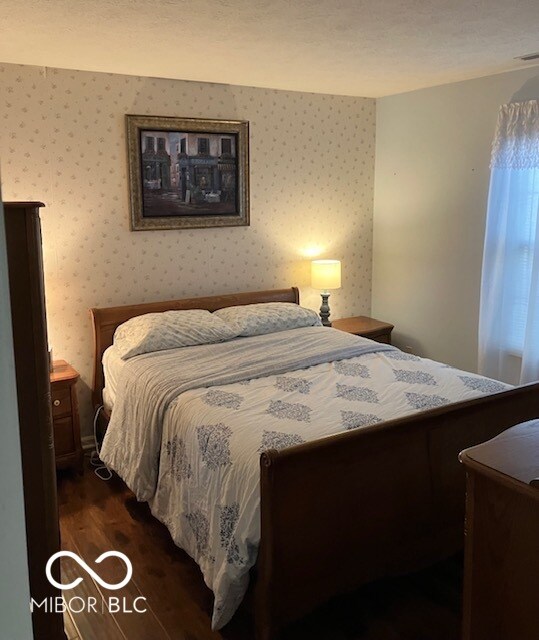 bedroom with dark wood-type flooring