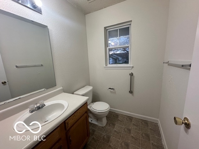 bathroom featuring vanity, a textured ceiling, and toilet