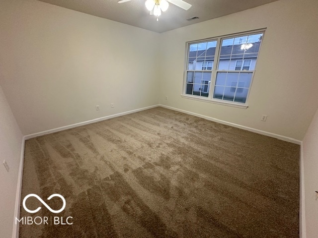 carpeted spare room featuring ceiling fan