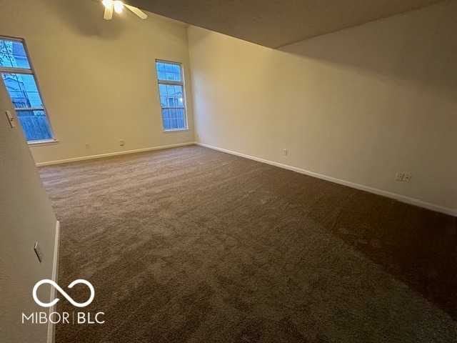 carpeted spare room featuring ceiling fan