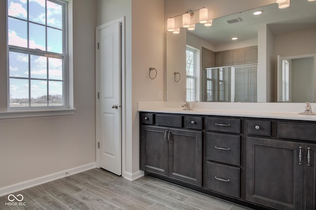 bathroom featuring a shower with door, vanity, and hardwood / wood-style flooring