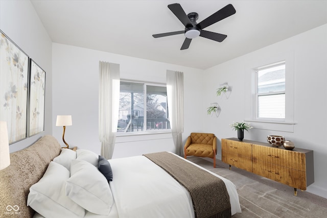 carpeted bedroom with ceiling fan and multiple windows