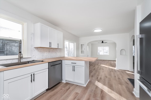 kitchen featuring sink, light hardwood / wood-style flooring, ceiling fan, appliances with stainless steel finishes, and white cabinetry