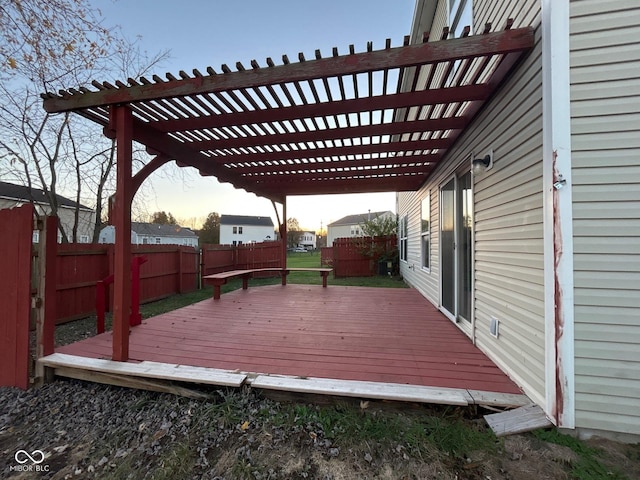 deck at dusk featuring a pergola