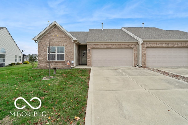 single story home with a garage and a front lawn