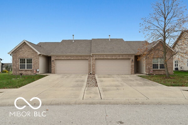 single story home featuring a garage and a front lawn