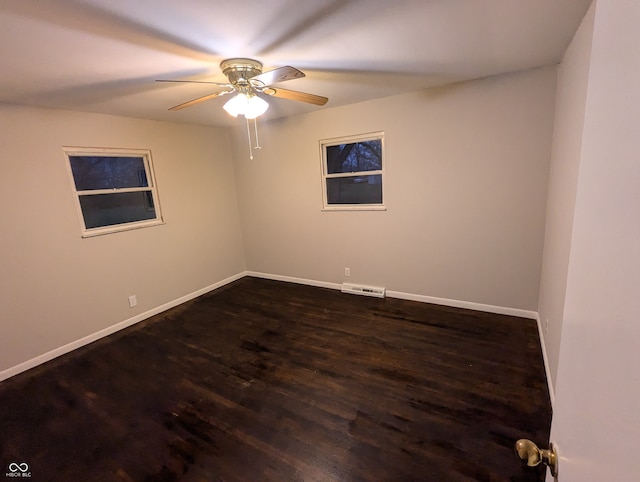 empty room featuring ceiling fan and dark wood-type flooring