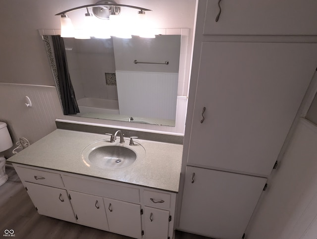 full bathroom featuring hardwood / wood-style floors, vanity, toilet, and shower / bath combo with shower curtain