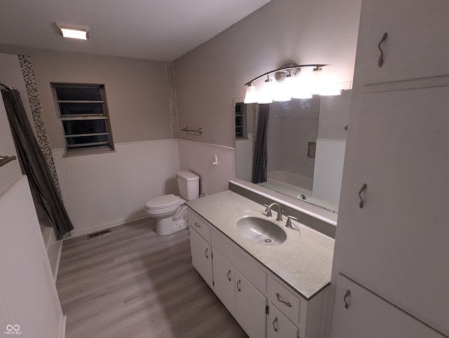 full bathroom with vanity, hardwood / wood-style flooring, toilet, and shower / tub combo with curtain