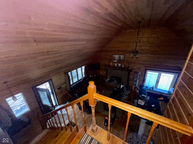 stairway featuring wooden walls, hardwood / wood-style floors, and lofted ceiling