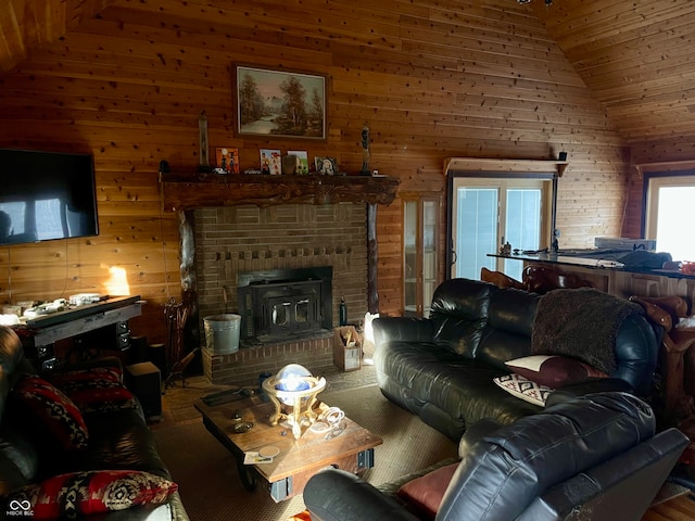 living room featuring wood walls, a wood stove, and high vaulted ceiling