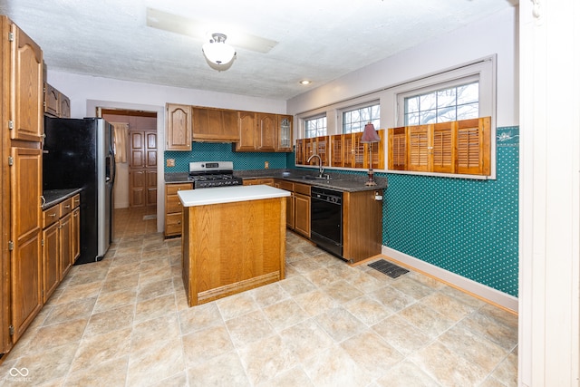 kitchen with sink, a kitchen island, stainless steel appliances, and a textured ceiling