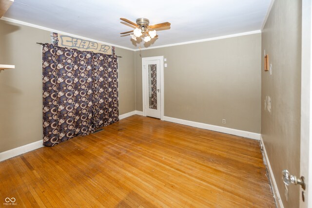 spare room with hardwood / wood-style flooring, ceiling fan, and crown molding