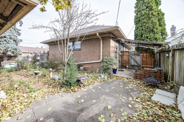 1330 N Bosart Ave, Indianapolis, IN 46201 - view of home's exterior with brick siding, a patio area, a fenced backyard, and a gate