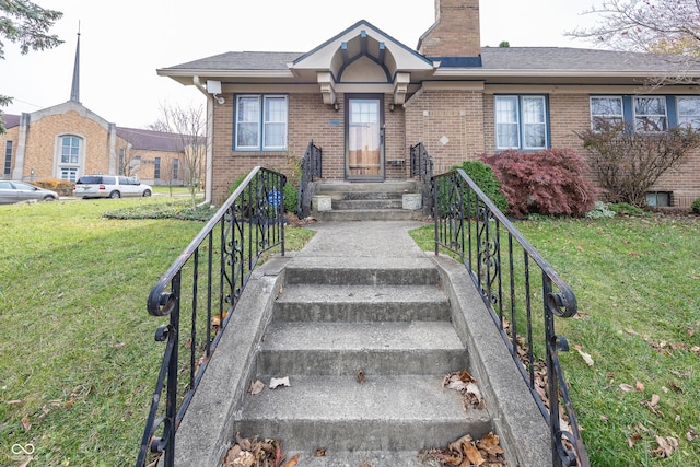 1330 N Bosart Ave, Indianapolis, IN 46201 - view of front facade featuring brick siding, a front yard, and a chimney