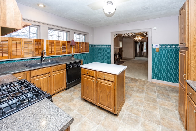 kitchen with ceiling fan, sink, stainless steel stove, black dishwasher, and a kitchen island