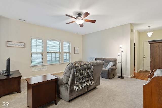 carpeted living room with ceiling fan