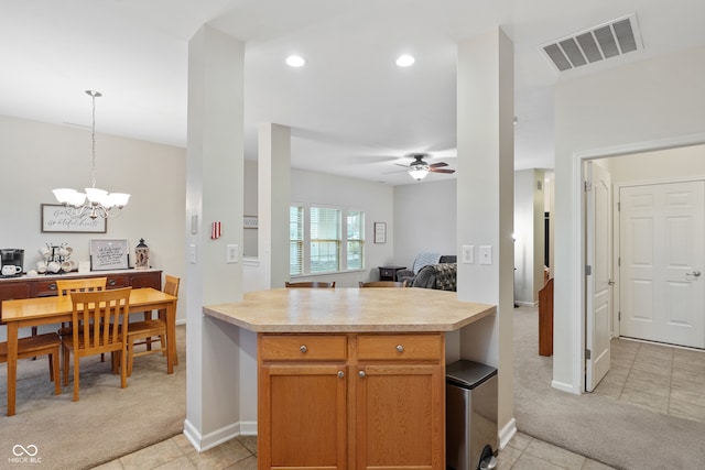 kitchen with light colored carpet, pendant lighting, and ceiling fan with notable chandelier