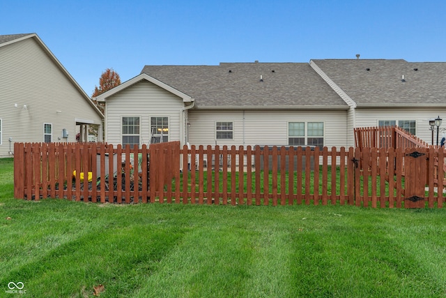 rear view of house featuring a lawn