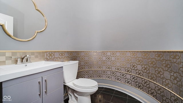 bathroom with tile patterned flooring, vanity, tile walls, and toilet