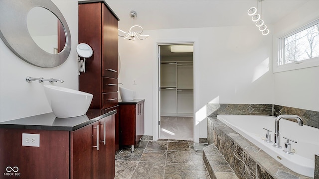 bathroom with vanity and a relaxing tiled tub