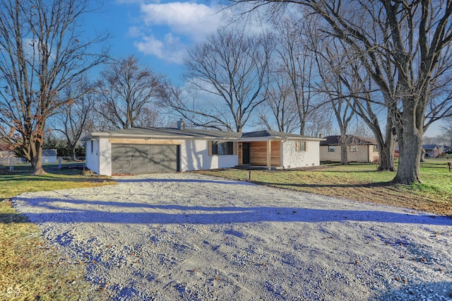 ranch-style home featuring a garage and a front lawn