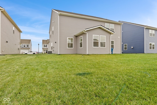 rear view of house featuring a lawn