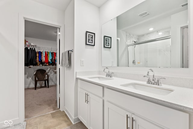 bathroom with tile patterned flooring, vanity, and walk in shower