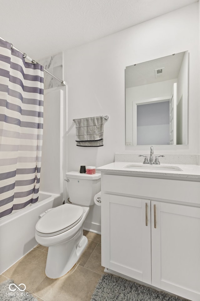 full bathroom with vanity, a textured ceiling, shower / bath combo with shower curtain, tile patterned flooring, and toilet