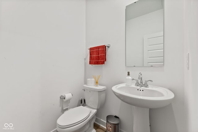 bathroom featuring sink, wood-type flooring, and toilet