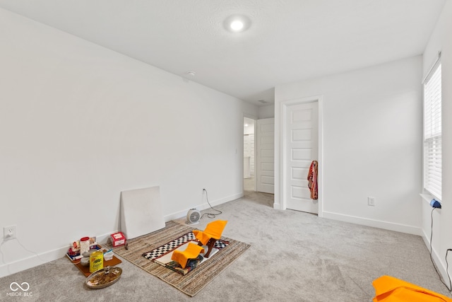 recreation room featuring light colored carpet