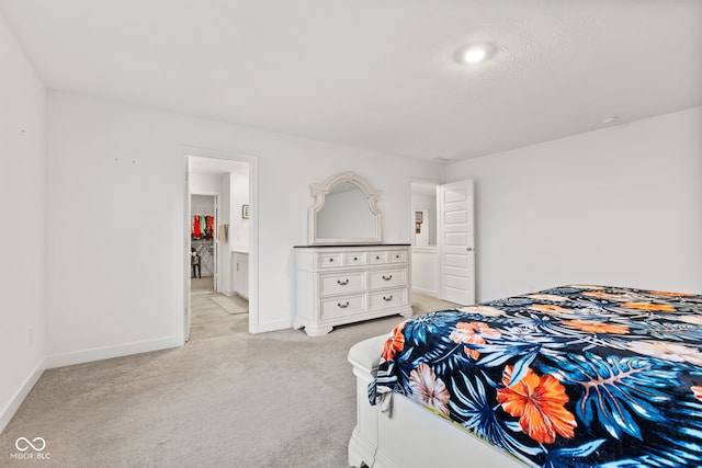 bedroom featuring light carpet and connected bathroom