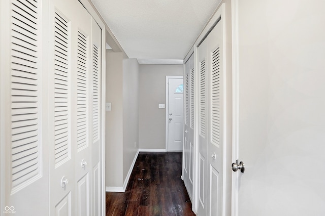 hallway featuring dark hardwood / wood-style floors and a textured ceiling