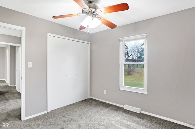 unfurnished bedroom with ceiling fan, a closet, and carpet floors