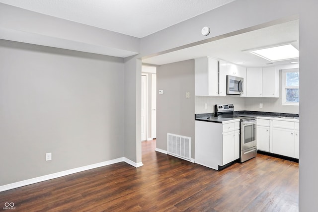 kitchen with white cabinetry, dark wood-type flooring, and appliances with stainless steel finishes