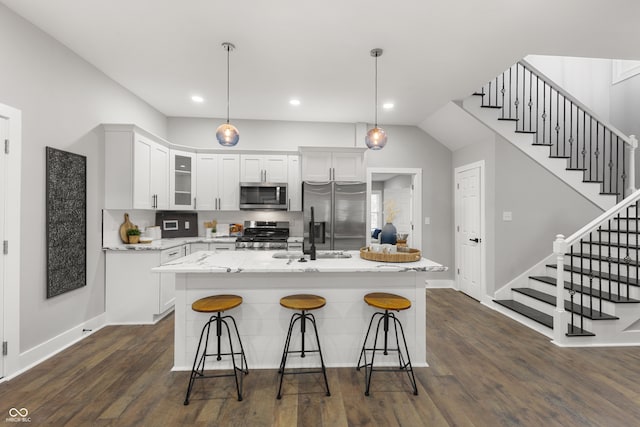 kitchen with a kitchen island with sink, stainless steel appliances, and dark hardwood / wood-style floors