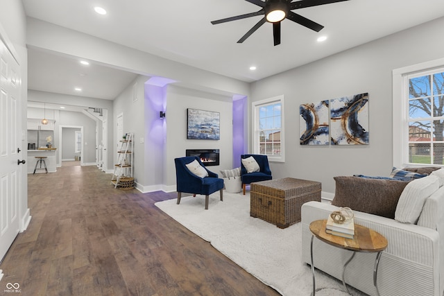 living room with ceiling fan and dark hardwood / wood-style flooring