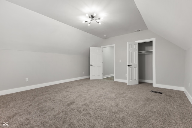 additional living space featuring a notable chandelier, carpet floors, and vaulted ceiling