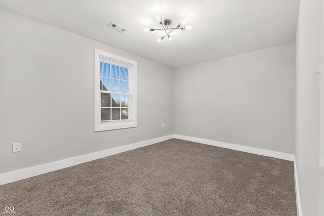 spare room with carpet and an inviting chandelier