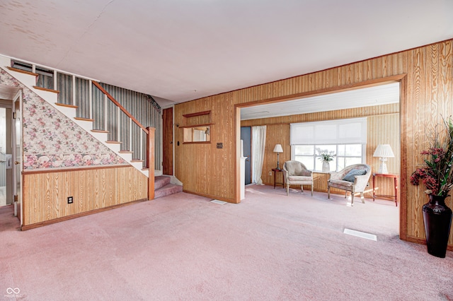 carpeted living room featuring wooden walls