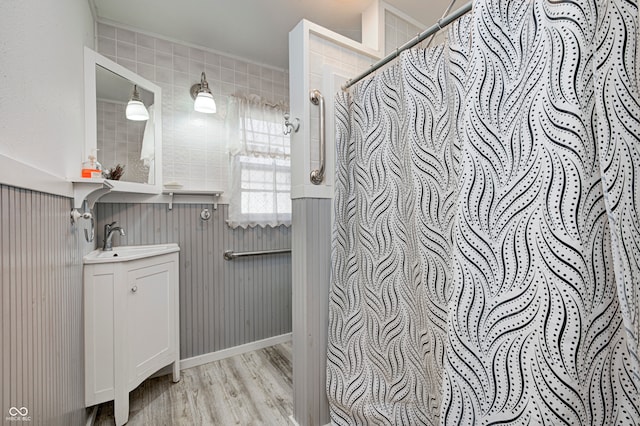 bathroom featuring crown molding, hardwood / wood-style floors, vanity, and walk in shower