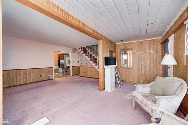 unfurnished room featuring carpet flooring and wooden walls