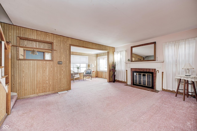 80 S Mickley Ave, Indianapolis, IN 46241 - unfurnished living room with a brick fireplace, wooden walls, stairs, and carpet