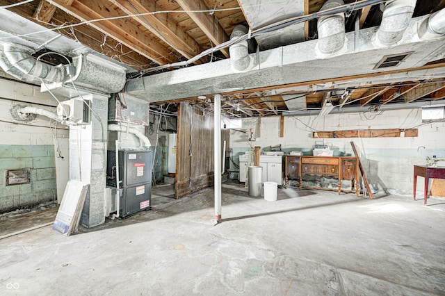 basement with washing machine and clothes dryer, heating unit, and gas water heater