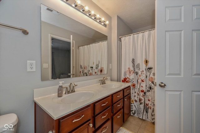 bathroom featuring vanity, a textured ceiling, and tile patterned floors