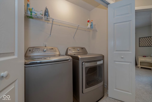 laundry area featuring light carpet and washer and clothes dryer