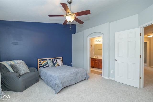 carpeted bedroom with ceiling fan, ensuite bath, and vaulted ceiling