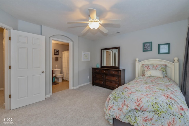 carpeted bedroom featuring ensuite bath and ceiling fan