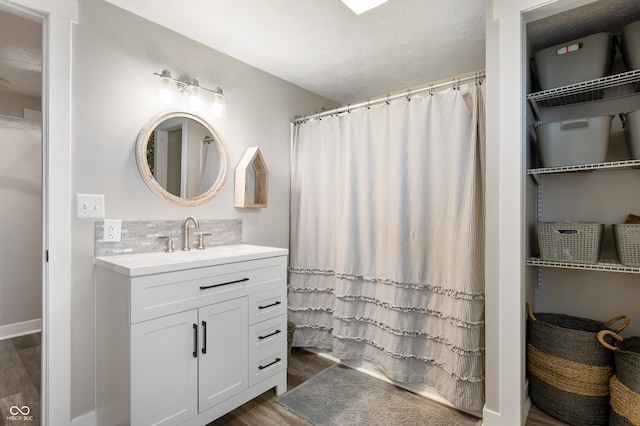 bathroom with vanity, backsplash, a shower with curtain, and hardwood / wood-style floors